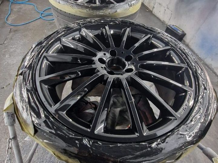 Alloy wheel freshly refurbished in gloss black